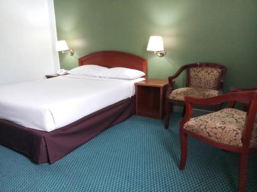 Hotel Seri Malaysia Johor Bahru في جوهور باهرو: غرفة فندقية فيها سرير وكرسي وسرير ومكتب