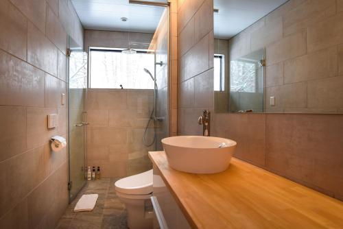 a bathroom with a large sink and a toilet at Akamatsu House in Hakuba