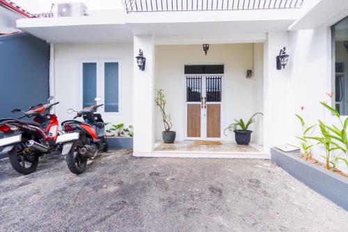 two motorcycles parked in front of a house at OYO 2975 House Of Mahira Syariah in Ciamis