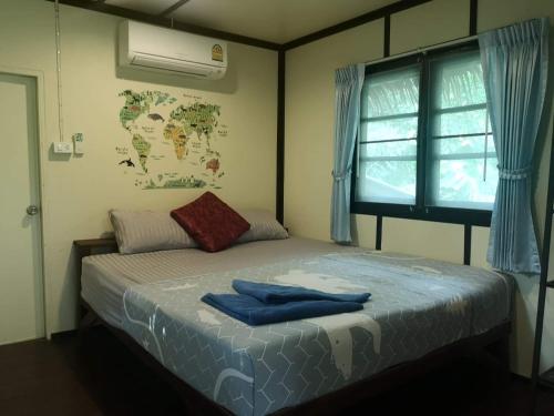 Un dormitorio con una cama con toallas azules. en Jungle Garden, en Ko Chang