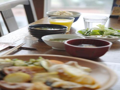 a table with bowls and plates of food on it at Sunsky Hotel in Kitakyushu