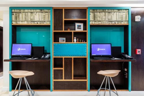 a room with two desks with two laptops on them at Premier Inn Doha Airport in Doha