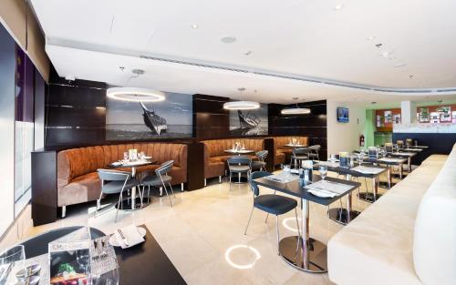 a restaurant with tables and chairs and a bar at Premier Inn Doha Airport in Doha