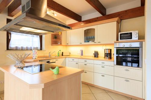 a large kitchen with white cabinets and a sink at Ferienwohnung Isabella am Möhnesee in Möhnesee