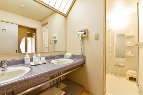 a bathroom with two sinks and a shower at Annex Fujiya Ryokan in Kaminoyama