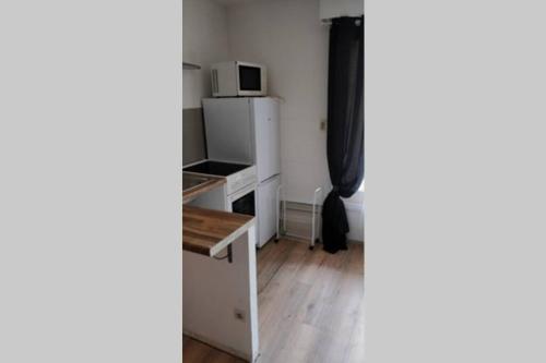 a room with a white refrigerator and a microwave at Studio de charme en centre ville D1 in Douai