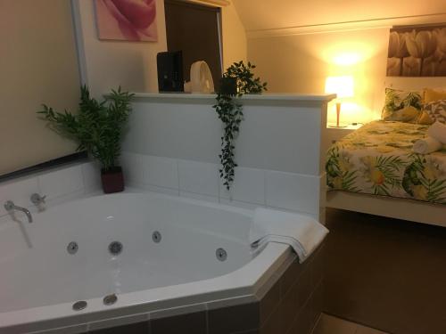 a large bath tub in a room with a bed at Villa Serenity On The Terrace in Mandurah