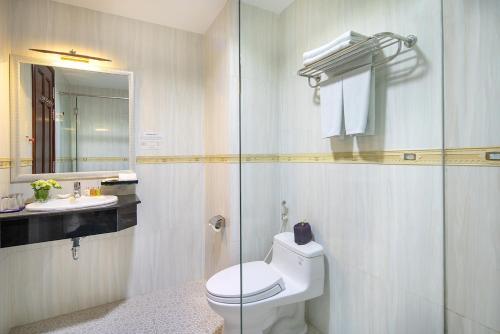 a bathroom with a toilet and a glass shower at Nesta Hotel Can Tho in Can Tho