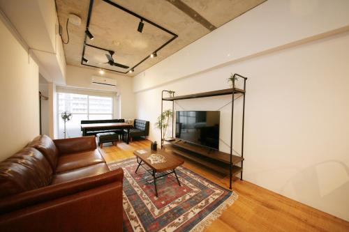 a living room with a couch and a television at goom Hotel Hakata-Higashihie-Ekimae in Fukuoka