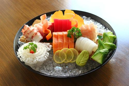 a plate of food with sushi on a table at Novotel Ahmedabad in Ahmedabad