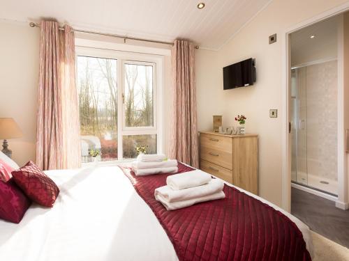 a bedroom with a large bed with towels on it at Waternook Lodge in Carnforth