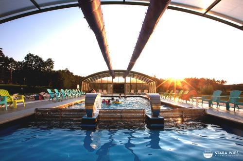 uma piscina com um gazebo e uma piscina em Resort Stara Wieś em Załęcze Małe