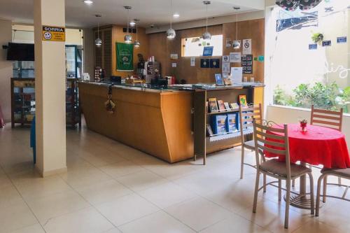 a restaurant with a red table and chairs and a counter at Hotel Venturim in Venda Nova do Imigrante