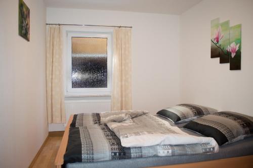 uma cama num quarto com uma janela em FeWo Bucker em Lauscha
