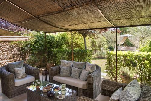 a patio with wicker furniture under a large umbrella at Borgo Santo Pietro in Chiusdino