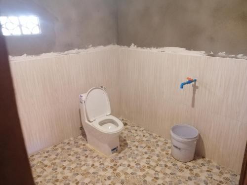 a bathroom with a toilet and a trash can at Tree Trails Homestay & Offers Jungle Trekk-Scooter For Rental in Banlung