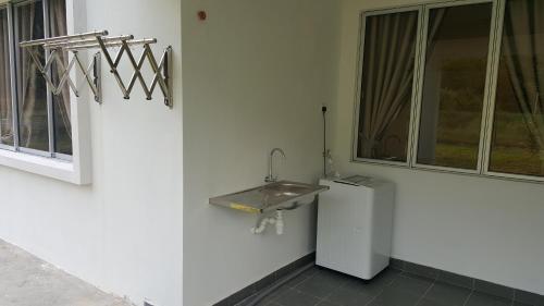 a bathroom with a sink and a washing machine at Seri Jati Homestay in Papar