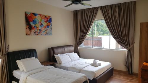 een hotelkamer met 2 bedden en een raam bij Seri Jati Homestay in Papar