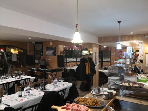 リモーネ・ピエモンテにあるB&B La Locanda del Colle e ristoranteの白いテーブルを着た料理を楽しめるレストラン