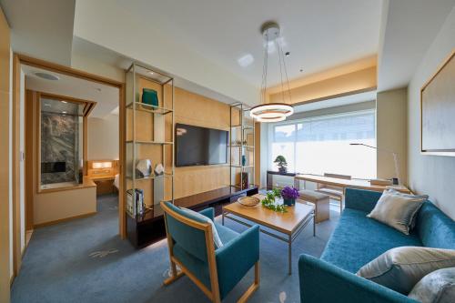 a living room with a blue couch and a table at THE KITANO HOTEL TOKYO in Tokyo