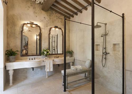 a bathroom with a shower and a sink and mirrors at Borgo Santo Pietro in Chiusdino