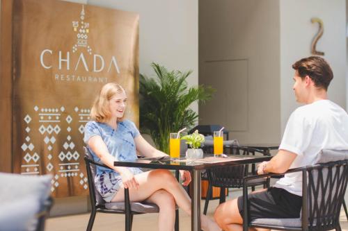 a man and a woman sitting at a table at Divalux Resort & Spa Bangkok, Suvarnabhumi Airport-Free Shuttle in Lat Krabang