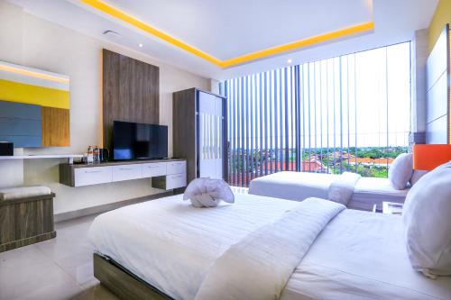 a hotel room with two beds and a television at Canggu Dream Village Hotel and Suites in Canggu