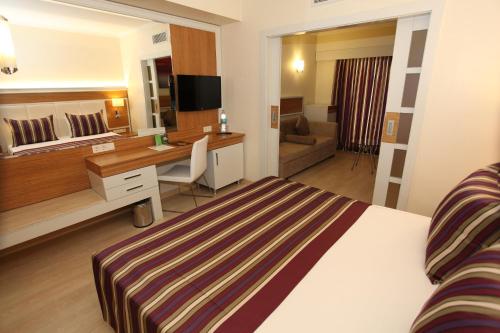 a hotel room with a bed and a desk at AQI Pegasos Royal in Avsallar