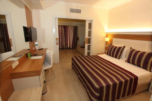 a hotel room with a bed and a desk at AQI Pegasos Royal in Avsallar