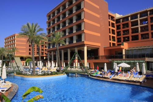 a hotel with a swimming pool in front of a building at AQI Pegasos Royal in Avsallar