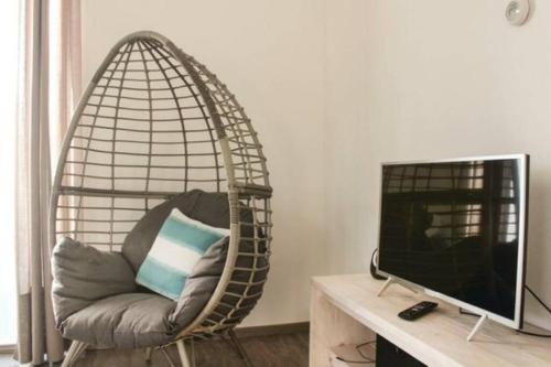a couch in a hanging chair next to a television at Vakantie met sauna in Zeeland in Sint Annaland