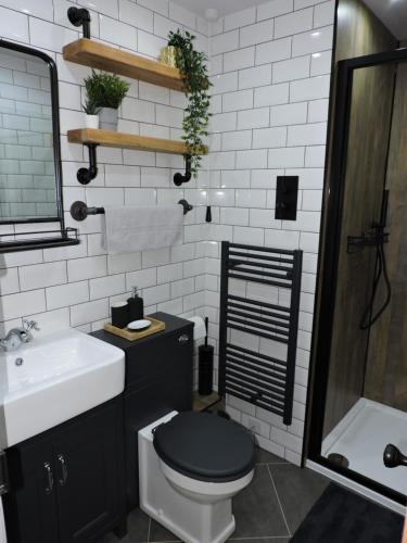 a bathroom with a black toilet and a sink at Scafell View Apartment, Wasdale, Lake District, Cumbria in Nether Wasdale