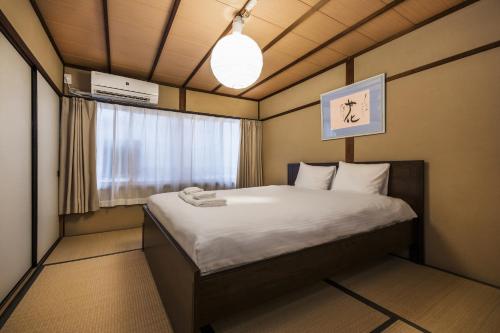 Kleines Zimmer mit einem Bett und einem Fenster in der Unterkunft Shiki Homes HARU in Kyoto