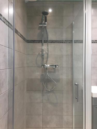 une douche avec une porte vitrée dans une salle de bain dans l'établissement APPARTEMENTS ACCES PRIVE PLAGE DE LA BERGERIE, à Hyères