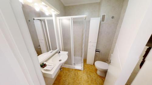 a white bathroom with a sink and a toilet at Apartamentos Design Pinemar in Cabañas