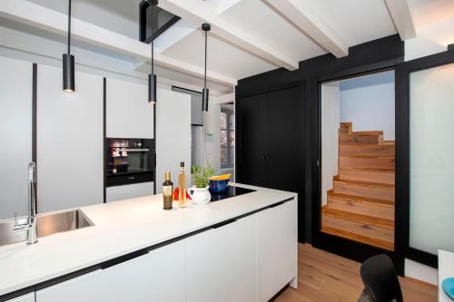 uma cozinha com armários brancos e uma escadaria em Alla Pescheria em Rovinj