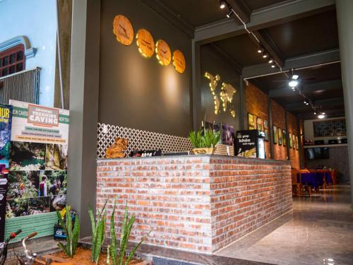 a restaurant with a brick counter with plants on the wall at Thao Nguyen Homestay in Phong Nha