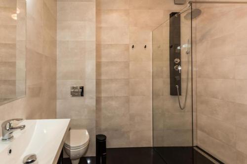 a bathroom with a shower and a sink and a toilet at Apartamenty Planet in Warsaw