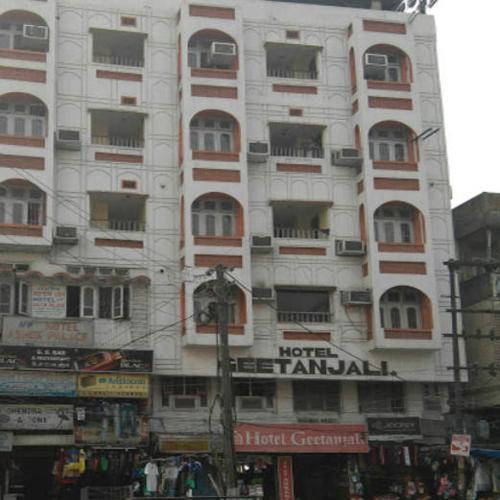ein großes weißes Gebäude mit Fenstern auf einer Stadtstraße in der Unterkunft Hotel Geetanjali in Guwahati