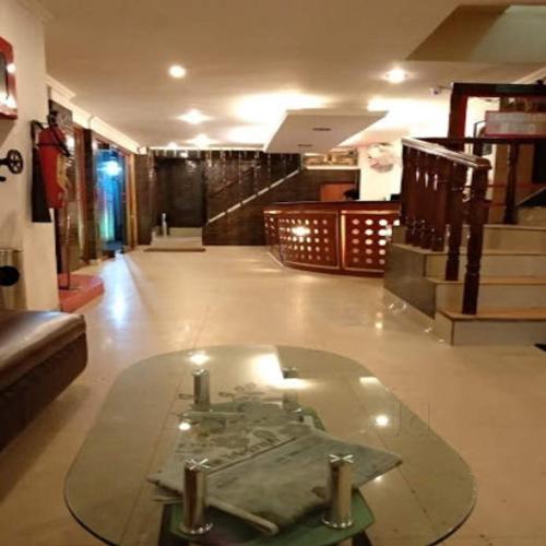 ein Zimmer mit einem Glastisch in der Mitte eines Gebäudes in der Unterkunft Hotel Geetanjali in Guwahati