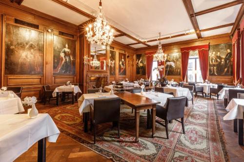 une salle à manger avec des tables, des chaises et des peintures dans l'établissement Fletcher Hotel Paleis Stadhouderlijk Hof, à Leeuwarden