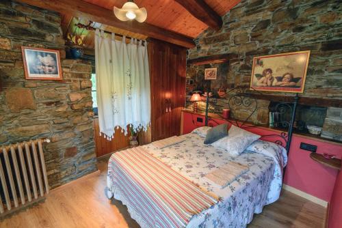 1 dormitorio con 1 cama en una pared de piedra en Esquíos - Apto. El Pajar, en Taramundi