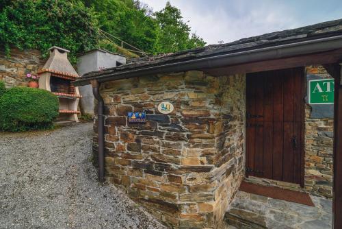 a stone building with a sign on the side of it at Esquíos - Apto. El Pajar in Taramundi