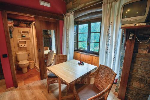 ein Esszimmer mit einem Holztisch und Stühlen in der Unterkunft Esquíos - Apto. El Pajar in Taramundi