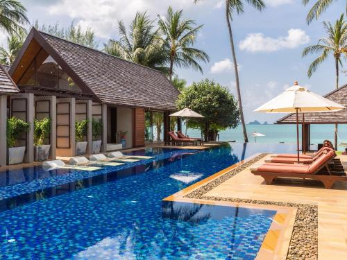 a pool at a resort with a view of the ocean at Baan Puri - SHA Extra Plus in Lipa Noi