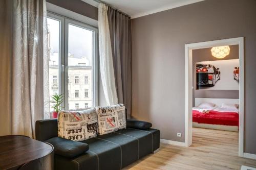 a living room with a couch and a bed and a mirror at Apartamenty Planet in Warsaw