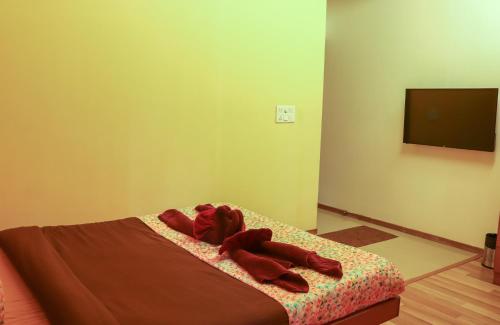 a bedroom with a bed with red clothes on it at Surya Kiran Miramar in Panaji