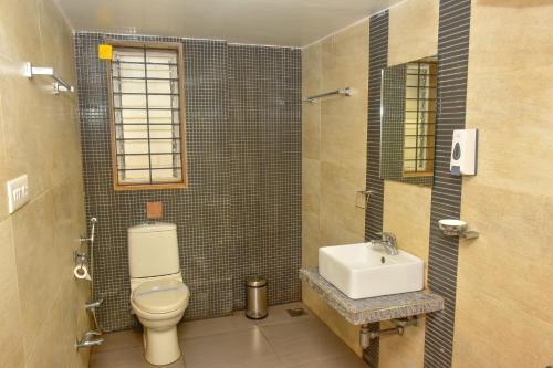 a bathroom with a toilet and a sink at Surya Kiran Miramar in Panaji