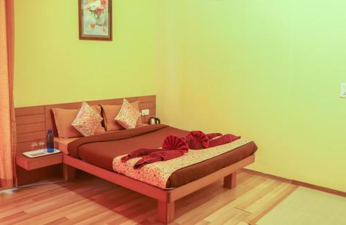 a bedroom with a bed with red blankets and pillows at Surya Kiran Miramar in Panaji
