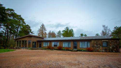 a house with a gravel driveway in front of it at Old Pines Hotel And Restaurant in Spean Bridge